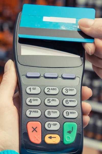 非接触クレジットカードで支払い端末を使用して女性の手 お店で買い物をするためのキャッシュレス支払い ファイナンスの概念 — ストック写真