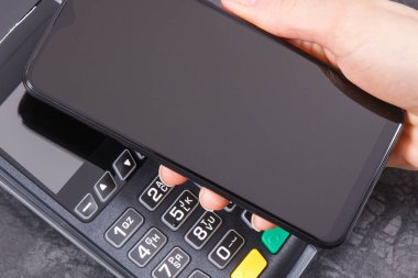 Cep telefonu ya da ödeme terminali olan akıllı telefon. Kredi kartı okuyucu. Alışveriş için para ödemeden. Finans ve bankacılık kavramı