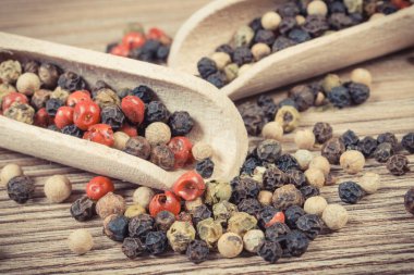 Ahşap tahtada pişirme baharatı olarak renkli biber. Kokulu çeşni.