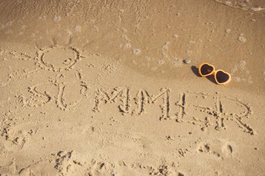 Yazın yazında güneş, güneş gözlüğü ve kumsalda gelen deniz dalgalarıyla birlikte. Seyahat ve tatil zamanı kavramı