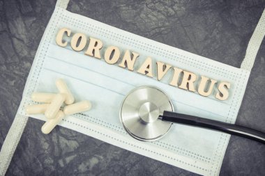Cerrahi veya koruyucu maske, tablet ve stetoskopla yazılmış koronavirüs. Romantik koronavirüs salgını. 2019-nCoV