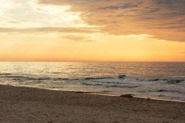 Gün batımının manzarası, dalgalı deniz ve plaj manzarası. Seyahat ve turizm konsepti. Yaz zamanı.