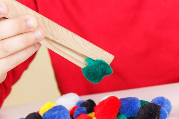Przedszkolak Bawiący Się Małymi Kolorowymi Pomponami Drewnianymi Szczypcami Rozwój Umiejętności — Zdjęcie stockowe