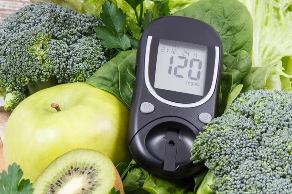 Glucose meter and fresh ripe green fruits with vegetables as healthy food containing natural vitamins. Diabetes and body detox