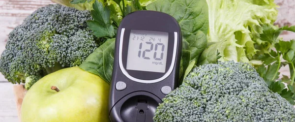 Glucose meter and fresh ripe green fruits with vegetables as healthy food containing natural vitamins. Diabetes and body detox