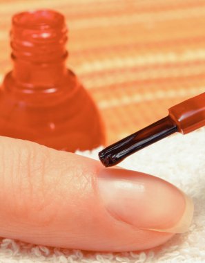 Kadının eline oje sürülmüş. Çivi bakımı ve manikür konsepti