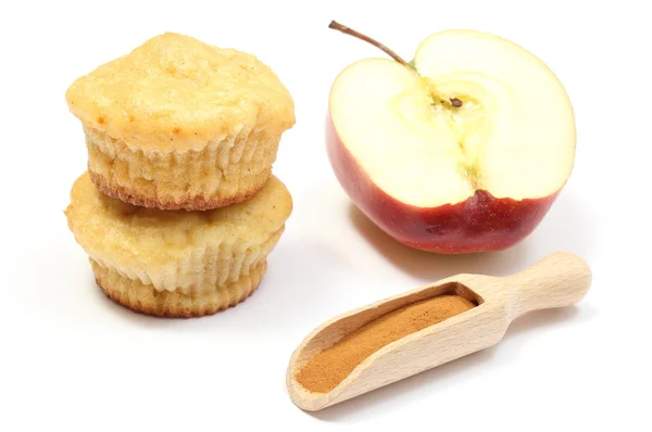 Stack of baked muffins, powdery cinnamon and half an apple. White background — Stock Photo, Image