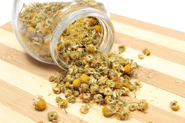 Heap of dried chamomile in glass jar — Stock Photo, Image