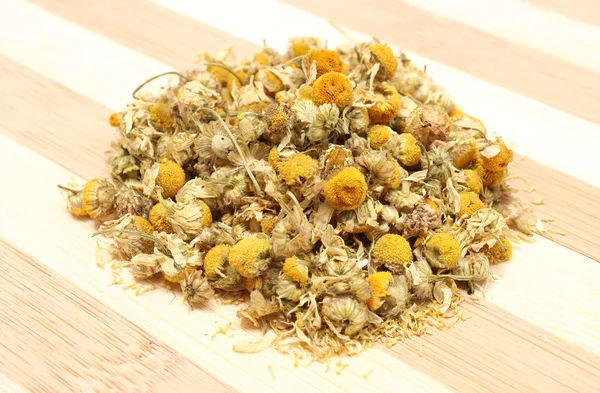 Heap of dried chamomile on wooden background — Stock Photo, Image