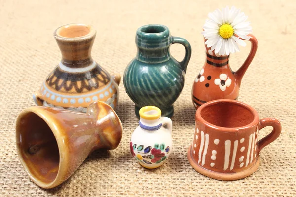 Decorative ceramic vases and white daisy on jute canvas — Stock Photo, Image