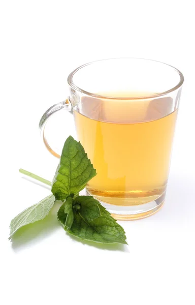 Fresh green mint and cup of beverage in background — Stock Photo, Image