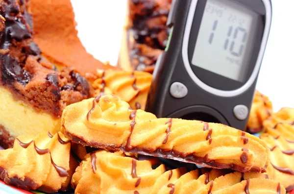 Fresh baked pastry and glucose meter. White background — Stock Photo, Image