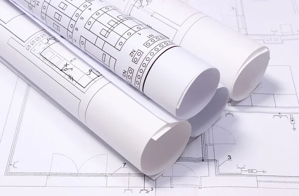 Rolled electrical diagrams on construction drawing of house — Stock Photo, Image