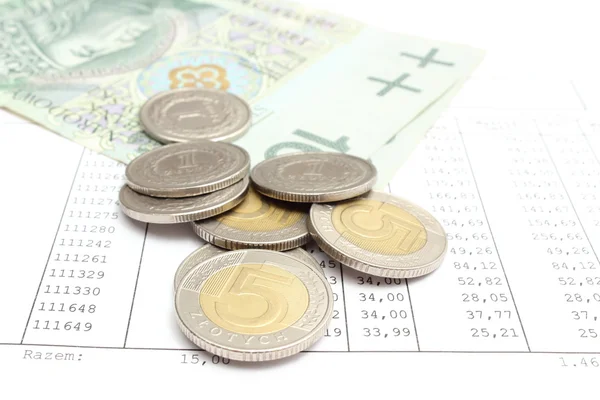 Pico de moedas e dinheiro de papel deitado em folha de cálculo — Fotografia de Stock