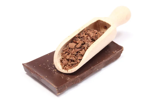 Pilha de chocolate escuro e ralado em colher de madeira — Fotografia de Stock