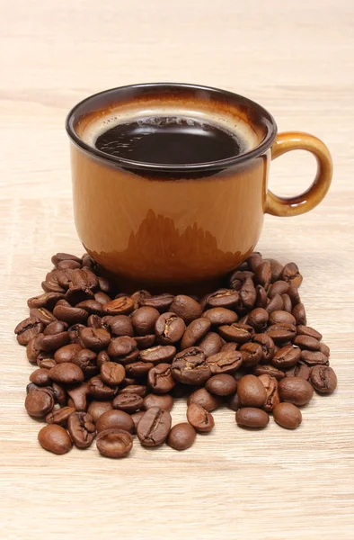 Hoop koffie korrels en kopje drank — Stockfoto