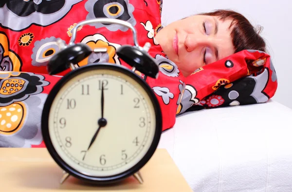 Brunette woman sleeping in her bedroom with alarm clock — Stock Photo, Image