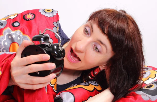 Surprised and amazed woman looking at alarm clock — Stock Photo, Image