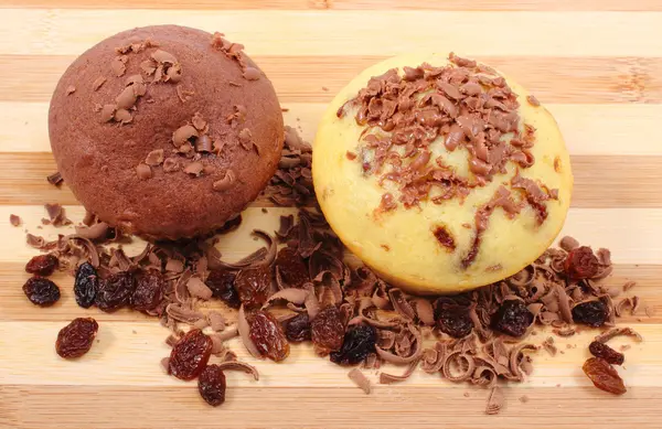 Fresh baked muffins and grated chocolate on wooden cutting board — Stock Photo, Image