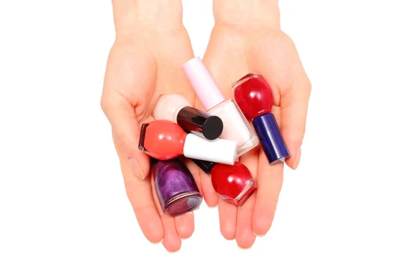 Manos de mujer y esmaltes de uñas sobre fondo blanco — Foto de Stock