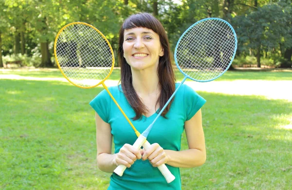 Femme souriante avec raquette de badminton dans le parc d'été — Photo