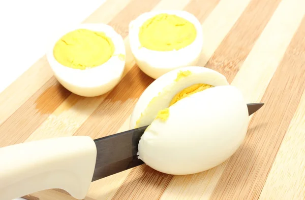 Halves of eggs with ceramic knife — Stock Photo, Image