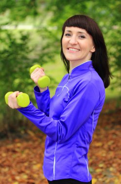 Esmer sırasında fitness egzersiz sonbahar Park dumbbells ile