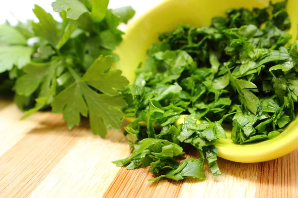 Fresh, natural and chopped parsley on wooden cutting board — Stock Photo, Image