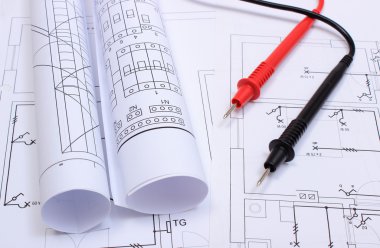 Elektrik diyagramları ve multimetre kabloları ev çizim üzerinde haddelenmiş
