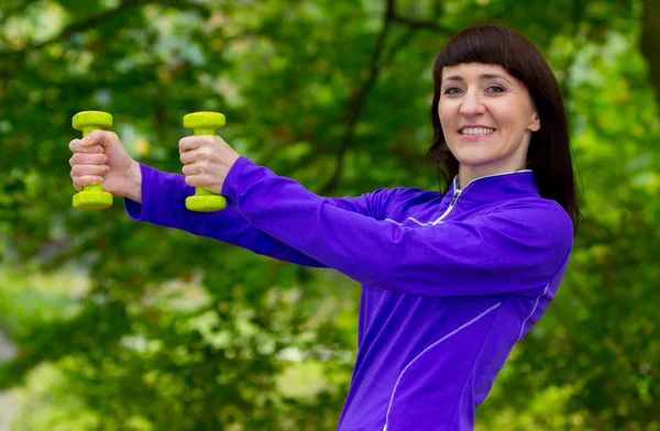 Esmer sırasında fitness egzersiz sonbahar Park dumbbells ile — Stok fotoğraf