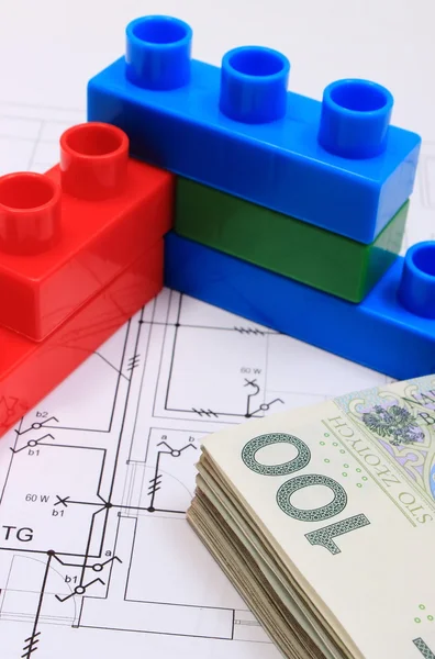 Heap of banknotes and building blocks on drawing of house — Stock Photo, Image