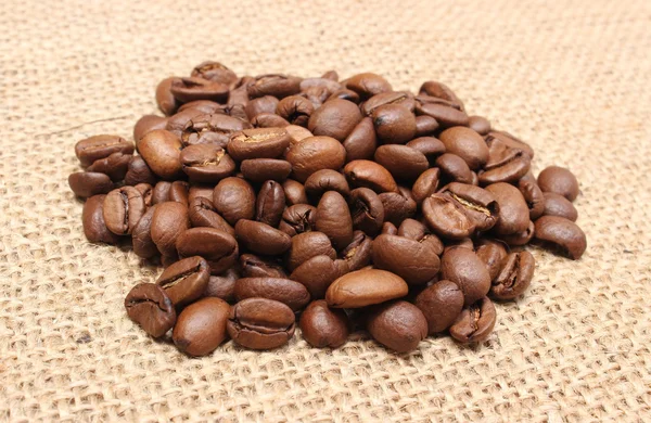 Куча кофе на джутовом фоне — стоковое фото