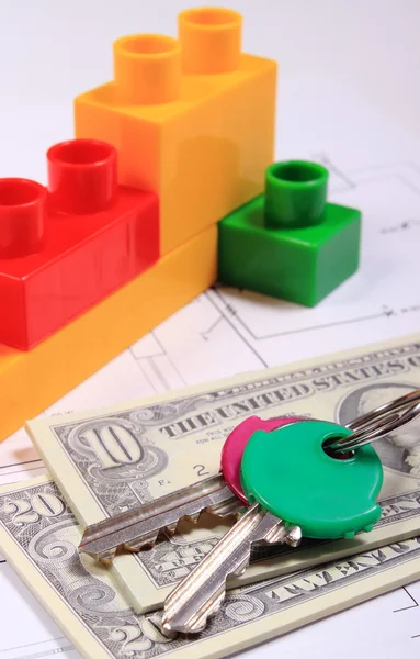 Banknotes, keys and building blocks on drawing of house — Stock Photo, Image