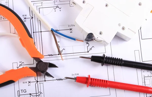 Cables of multimeter, pliers, electric fuse and wire on construction drawing — Stock Photo, Image