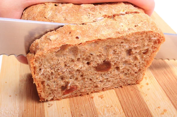 Hand of woman slicing fresh baked bread — Stock Photo, Image