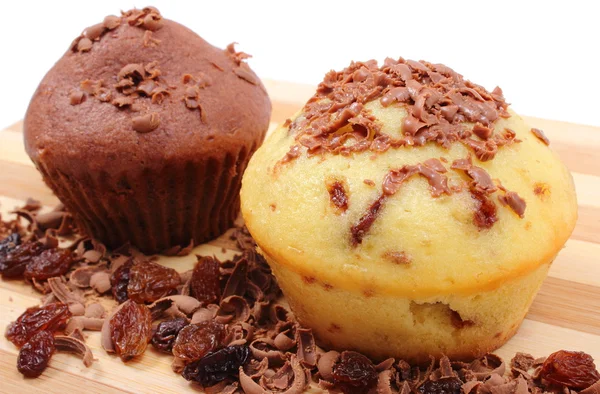 Fresh baked muffins and grated chocolate on wooden cutting board — Stock Photo, Image