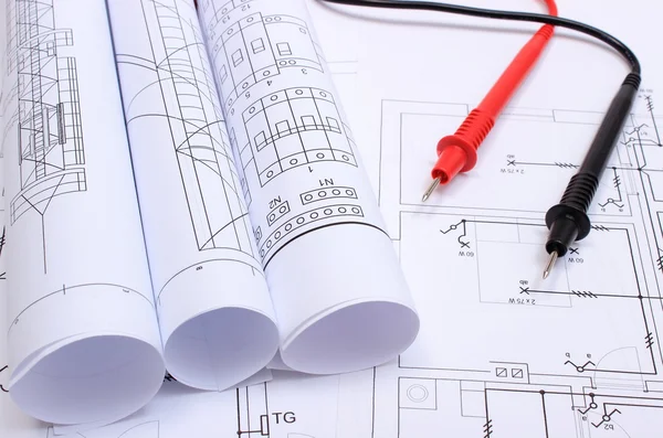 Gerollte elektrische Diagramme und Multimeterkabel auf der Zeichnung des Hauses — Stockfoto