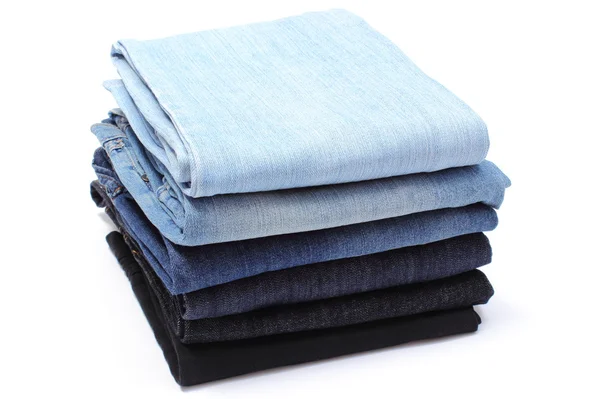 Куча синих джинсов на белом фоне — стоковое фото