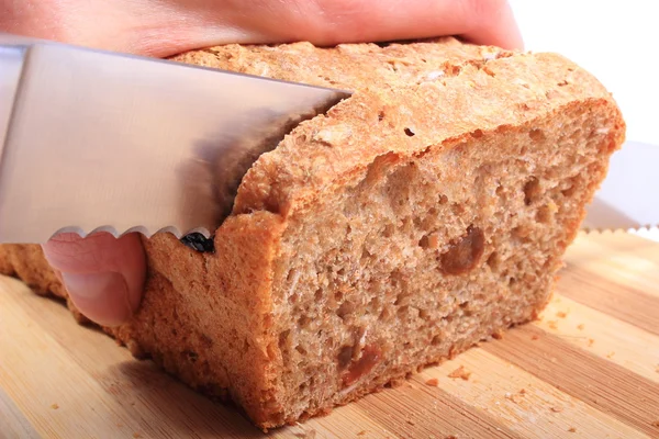 Mão de mulher cortando pão fresco assado — Fotografia de Stock