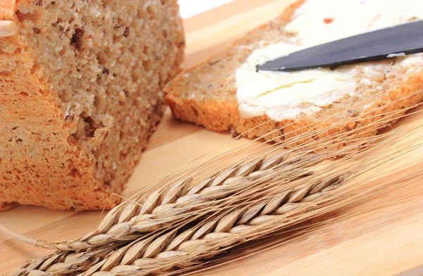 Fatia de pão com manteiga e espigas de trigo — Fotografia de Stock