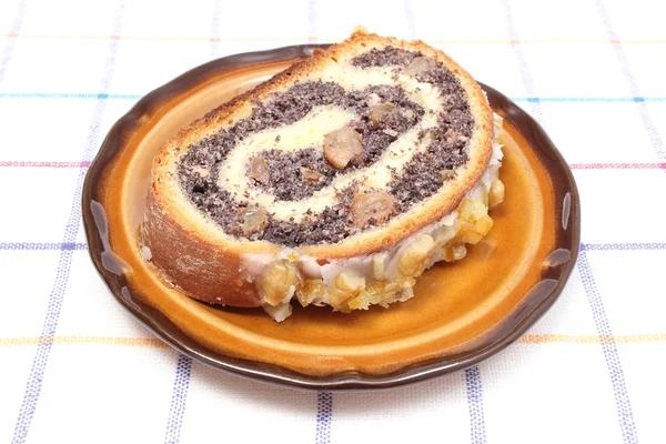 Piece of poppy seed cake lying on brown plate — Stock Photo, Image