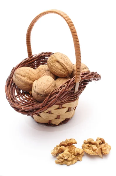 Stack of walnuts in wicker basket on white background — Stock Photo, Image
