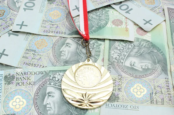 Médaille d'or et rouleau de billets attachés sur fond d'argent — Photo