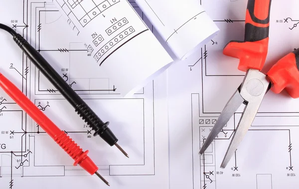 Elektriske diagrammer, kabler af multimeter og metaltænger - Stock-foto