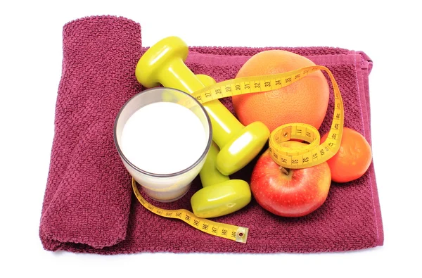 Fresh fruits, tape measure, milk and dumbbells on purple towel — Stock Photo, Image