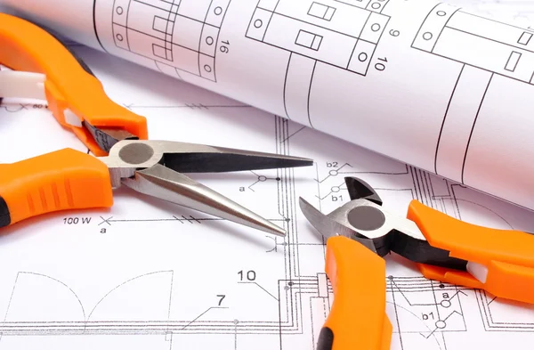 Pinces métalliques et diagramme électrique laminé sur le dessin de construction de la maison — Photo