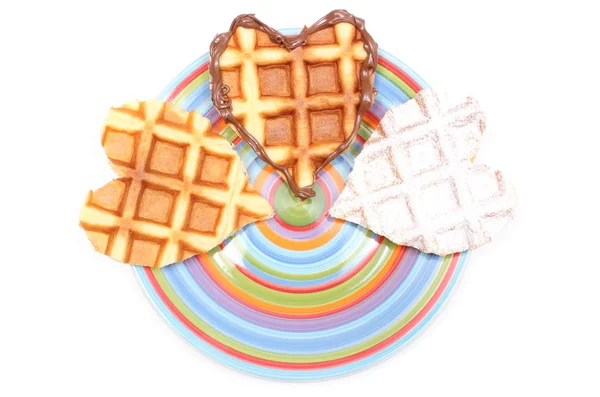 Waffles em forma de coração deitado em placa colorida. Fundo branco — Fotografia de Stock