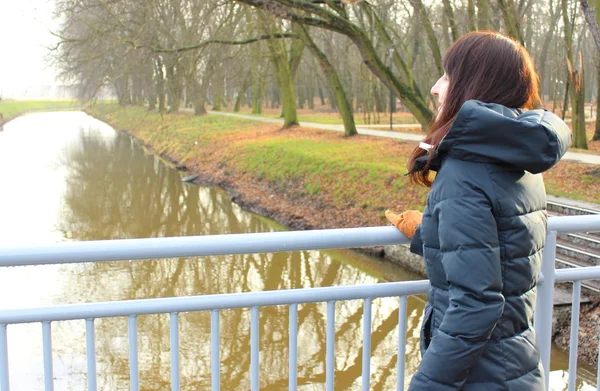 Mujer de pie en el puente y mirando a la distancia — Foto de Stock