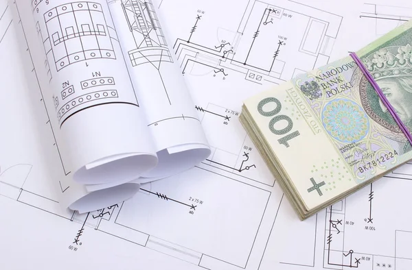 Heap of banknotes and electrical diagrams on construction drawing of house — Stock Photo, Image