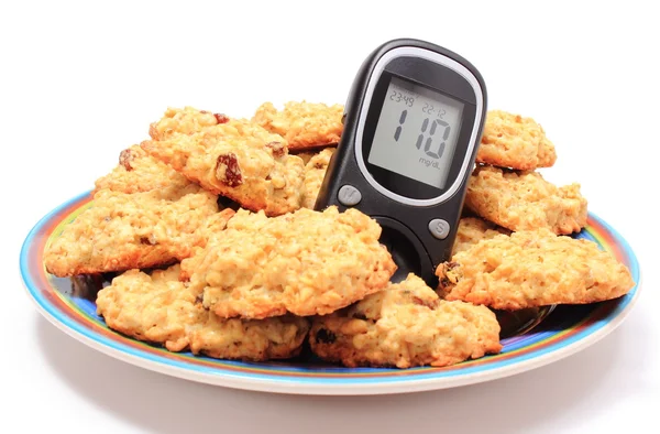 Glucose meter and oatmeal cookies on white background — Stock Photo, Image